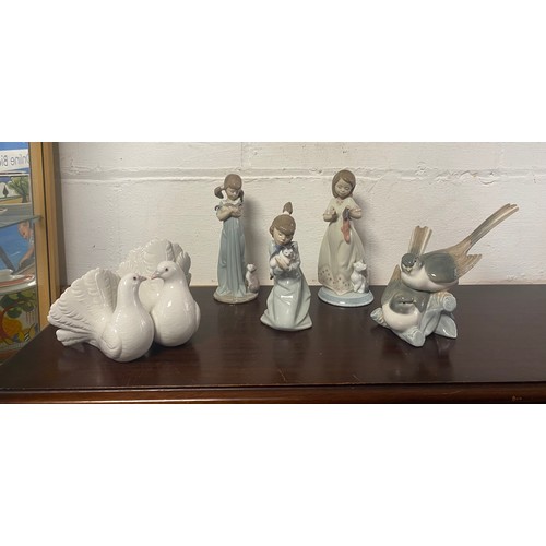 121 - A group of three Lladro figures of girls and cats, together with two doves and a group of swallows (... 