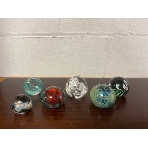 128 - A group of six modern glass paperweights, including Caithness and Mdina -