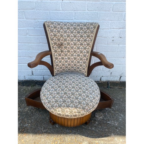 396 - An early 20th century armchair, with shaped back over circular seat with drawers underneath  -