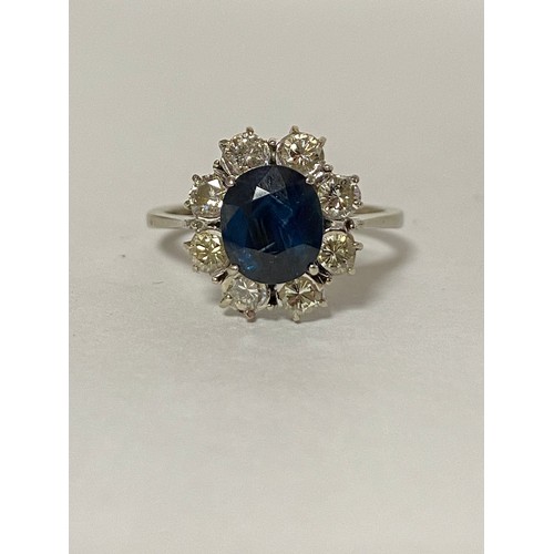 53 - A sapphire and diamond ring, of oval cluster design, the central sapphire in a surround of eight dia... 