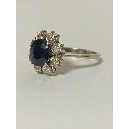 53 - A sapphire and diamond ring, of oval cluster design, the central sapphire in a surround of eight dia... 