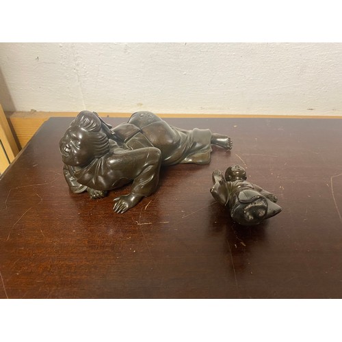 61 - A Japanese bronze, depicting two figures, signed to the underside -