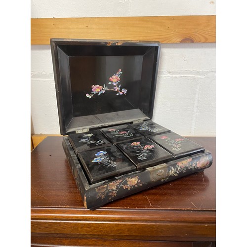 62 - A lacquered and inlaid Japanese counter box, the cover decorated with birds on branches, containing ... 