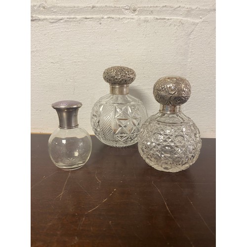 5 - A group of three silver mounted perfume bottles, the largest Birmingham 1912, one London 1911 and on... 