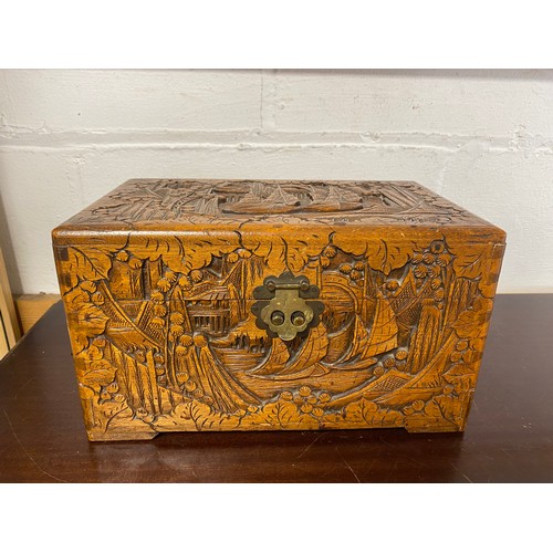 54 - An eastern carved hardwood box, decorated with boats and landscapes -