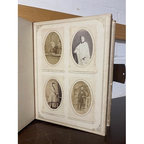 142 - A Victorian photograph album, containing approximately 100 carte de visites -