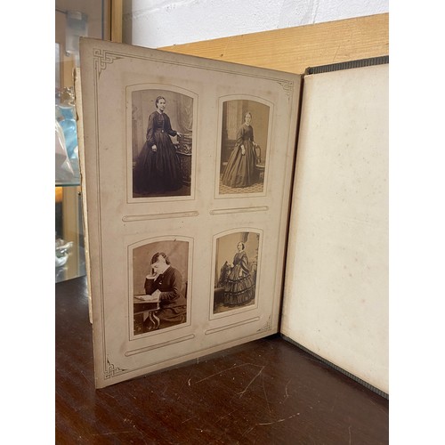 142 - A Victorian photograph album, containing approximately 100 carte de visites -