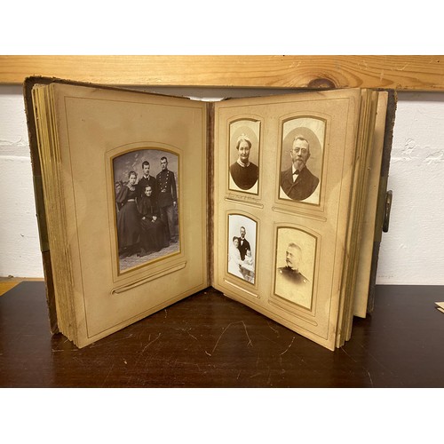 143 - A Victorian photograph album, containing approximately 68 carte de visites and photographs, and some... 
