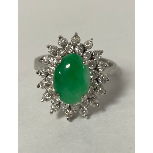 16 - A jade and diamond dress ring, the oval jade cabochon within two tiers of diamonds, to precious whit... 