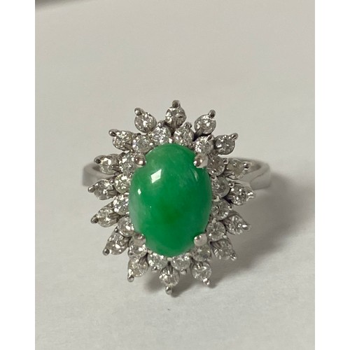 16 - A jade and diamond dress ring, the oval jade cabochon within two tiers of diamonds, to precious whit... 