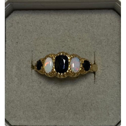 103 - A 9ct gold gem set ring, set with graduated opals and sapphire -