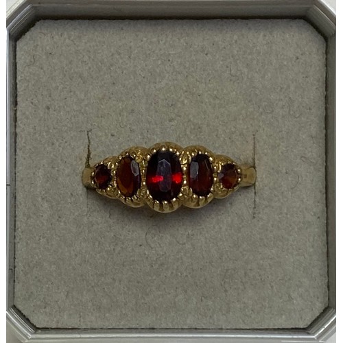 104 - A 9ct gold gem set ring, set with five graduated garnets -