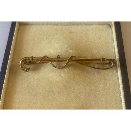 16 - A yellow metal brooch, set with an oval citrine and another of a riding crop (2) -