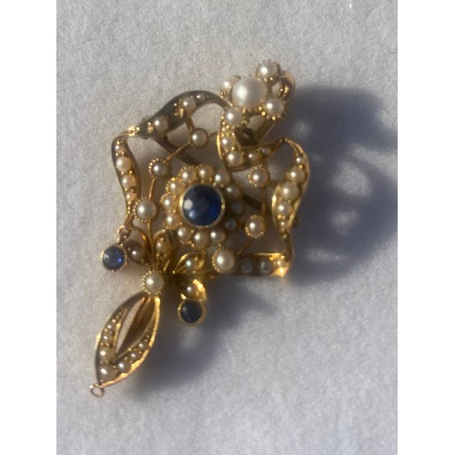 59 - An Edwardian 15ct gold openwork pendant/brooch, set with a central sapphire and seed pearl cluster w... 