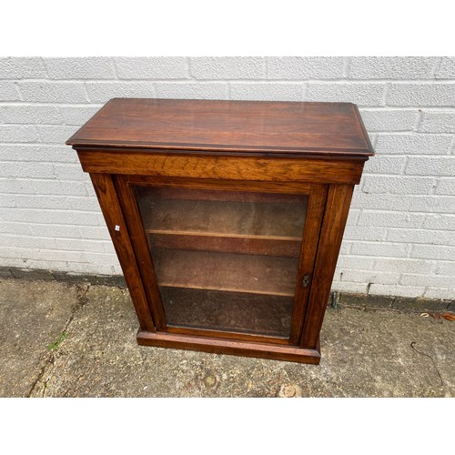 252 - A Victorian rosewood pier cabinet, with single glazed door enclosing lined shelves -