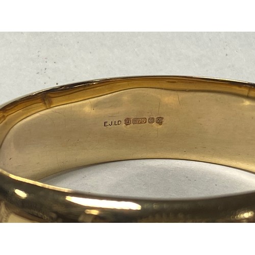 44 - A 9ct gold bangle, with engraved decoration -