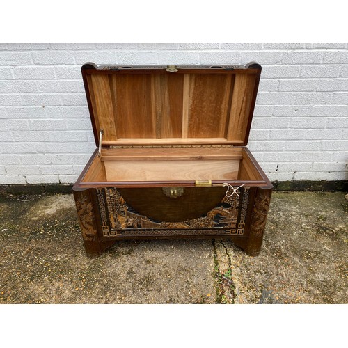 261 - A mid 20th century carved camphor chest, typically carved, with tray -