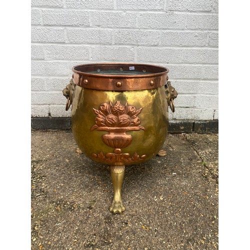 157 - A Victorian brass and copper log bin, with mask ring handles, armorial and fruit decoration and paw ... 