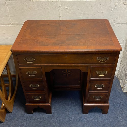 323 - A Georgian style kneehole desk, with crossbanded and line inlain top and frieze drawer, central cupb... 