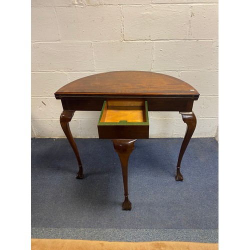 324 - A mahogany and crossbanded demi-lune foldover card table, on slender legs -