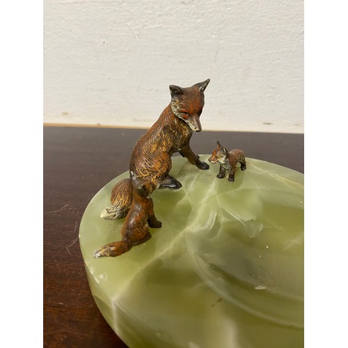 135 - An Edwardian cold painted bronze and onyx stand, applied with three bronze foxes -