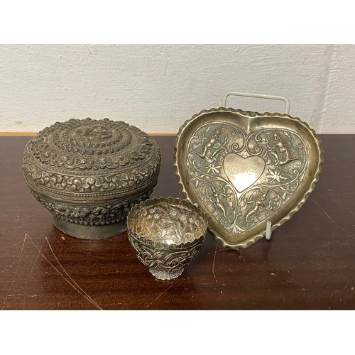 8 - An Eastern white metal box and cover, repousse decorated, together with a heart shaped dish and a sm... 