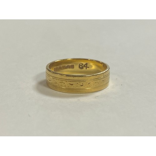 49 - An 18ct gold wedding band, with engraved decoration -