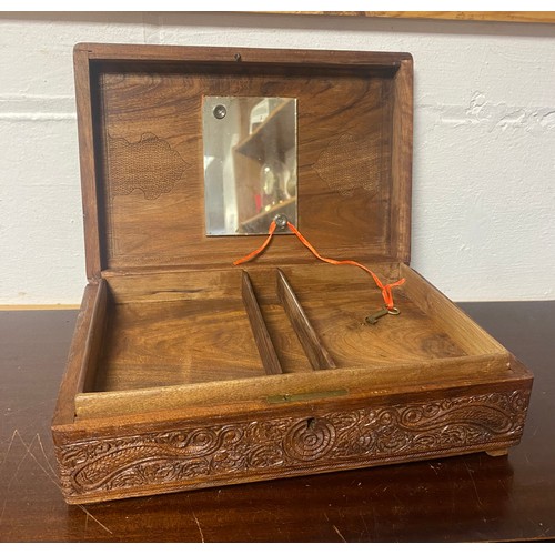 139 - An Indian hardwood box, with elaborately carved decoration, mirror inset to interior, with key -