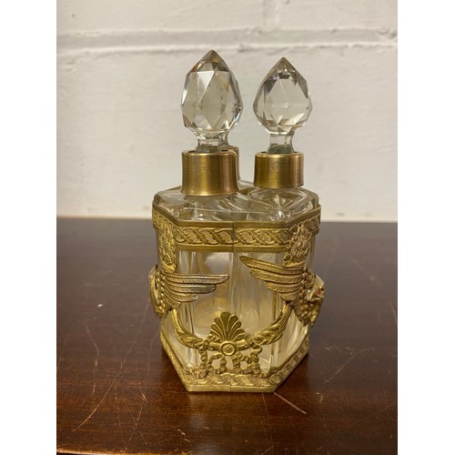 143 - A trio of cut glass scent bottles, in gilt metal stand, decorated with eagle heads