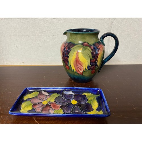 182 - A Moorcroft jug, decorated with flowers (handle and spout restored), together with a tray dish (2) -