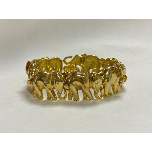 88 - A yellow metal bracelet, stamped 750, designed as a continuous line of elephants -