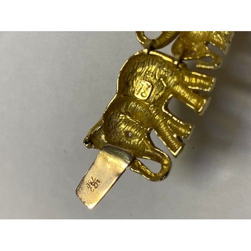 88 - A yellow metal bracelet, stamped 750, designed as a continuous line of elephants -