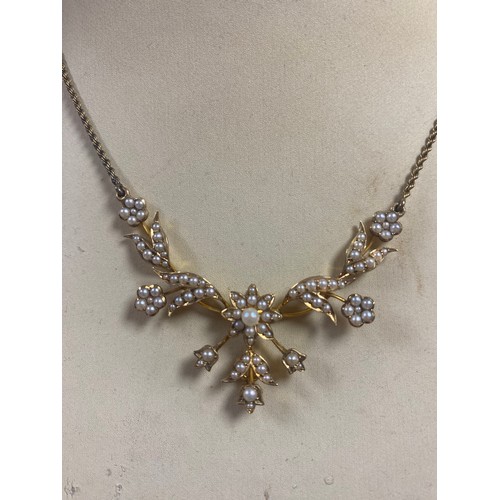 32 - A late Victorian/Edwardian 15ct gold seed pearl set necklace, set with articulated flowerheads and l... 