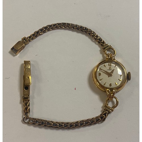 33 - A lady's Omega wristwatch, the signed dial in gold case, to 9ct gold bracelet strap -