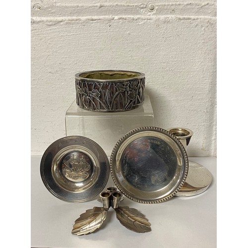 39 - A group of silver items, to include iris decorated coaster/dish, an Armada alms dish, dwarf candlest... 