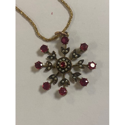 52 - A garnet and seed pearl set pendant, of snowflake design, to fine chain -