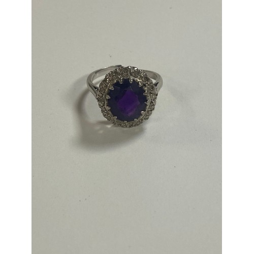 53 - An amethyst and diamond set dress ring, of oval cluster design, in precious metal mount (shank cut) ... 