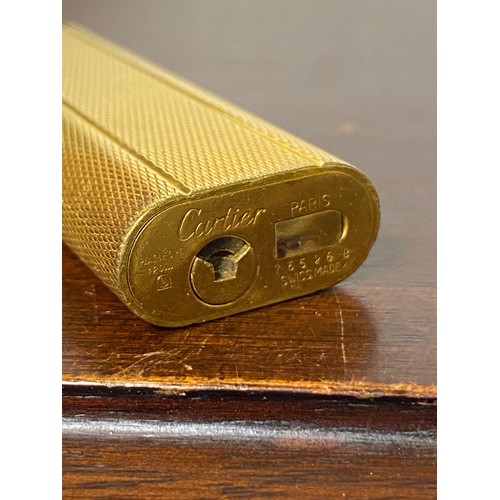 64 - Cartier: a gold plated lighter -