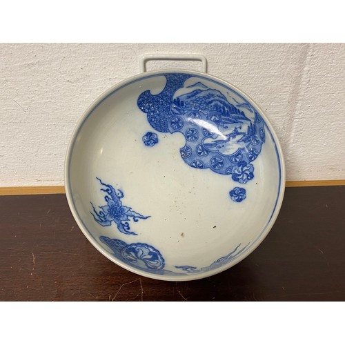 129 - A Chinese blue and white bowl, painted with a landscape panel with figure on a bridge -