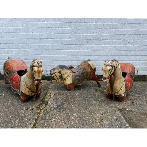 412 - A group of three 'folk art' carousel type carved and painted horses, each with typical decoration -