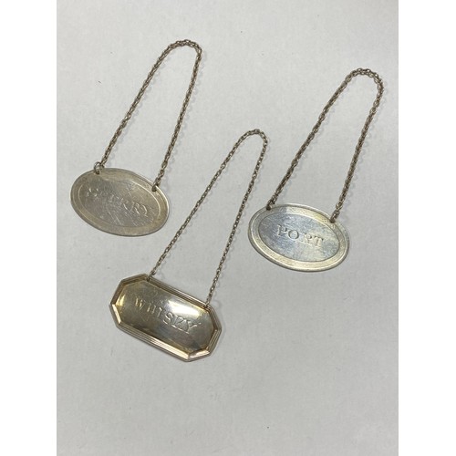 32 - A matched pair of silver decanter labels, 'Sherry' and 'Port', both of oval design and another 'Whis... 