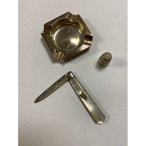 50 - A mother-of-pearl handled silver bladed fruit knife, a silver ashtray and a white metal thimble (3) ... 