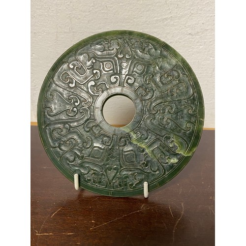 133 - A Chinese green hardstone bi, carved to each side with dragons -