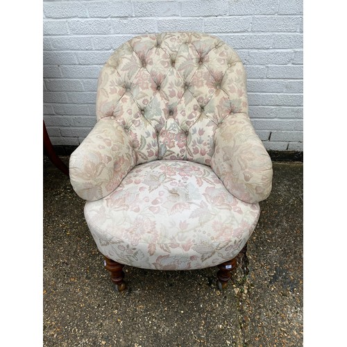 425 - A Victorian button back armchair, with floral upholstery, on short turned legs -