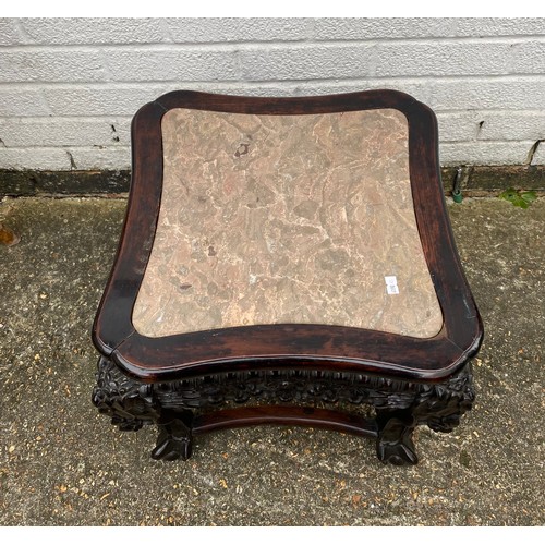 427 - A carved Chinese hardwood table, with elaborately carved frieze, marble inset top and claw and ball ... 