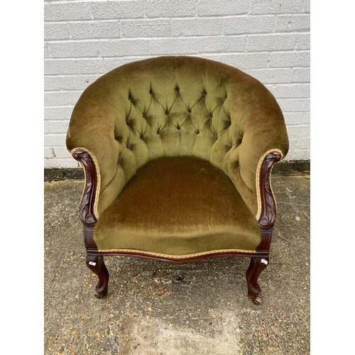 434 - A Victorian button back armchair, with carved frame and short legs -