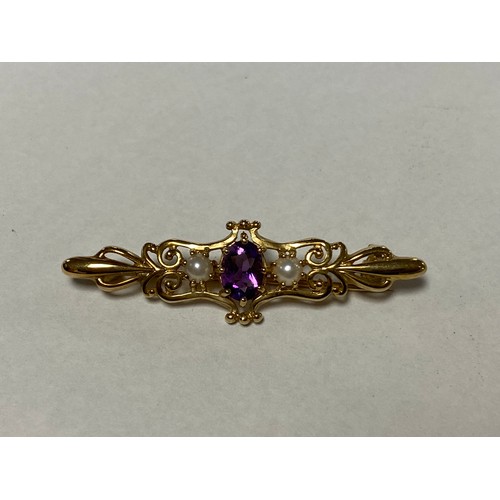 123 - A 9ct gold bar brooch, set with an oval amethyst and seed pearls -