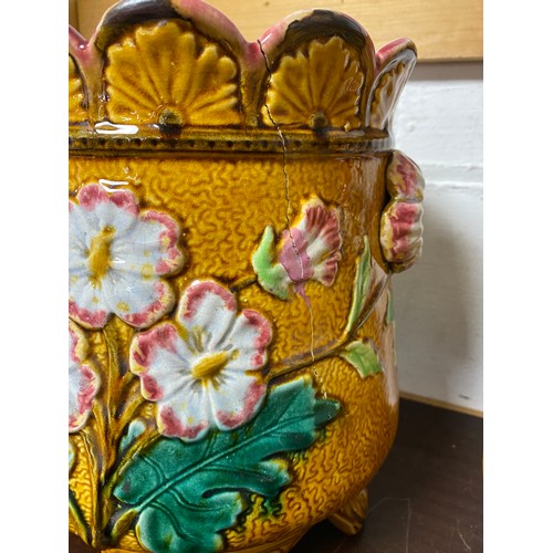 105 - A pair of 19th century majolica planters, each moulded with flowers on a mustard ground (a/f) -