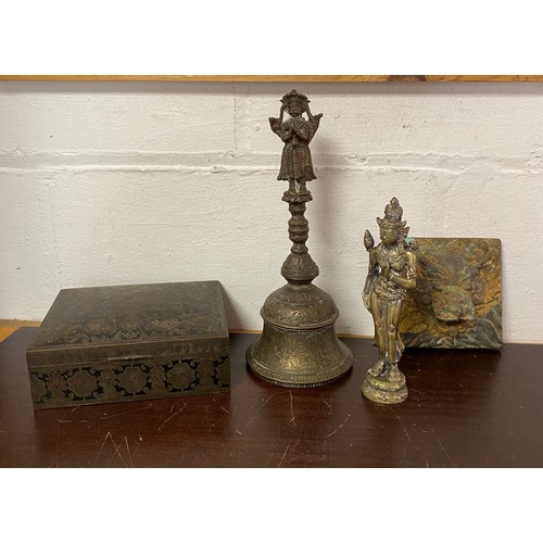 250 - An Indian ritual bell, together with a brass figure, a box and a dragon mask panel (4) -