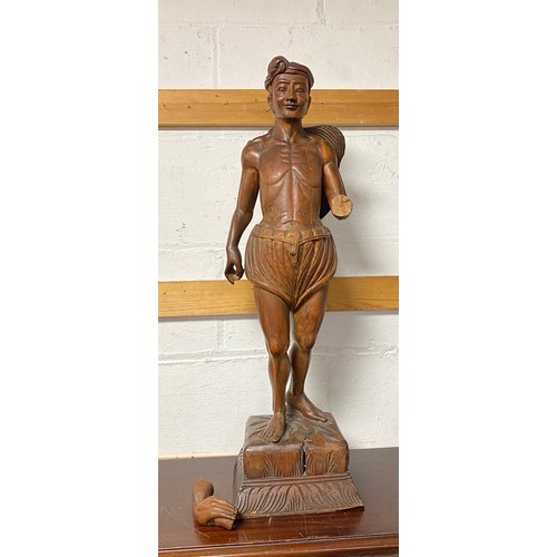 251 - An Indonesian carved hardwood model of a man -